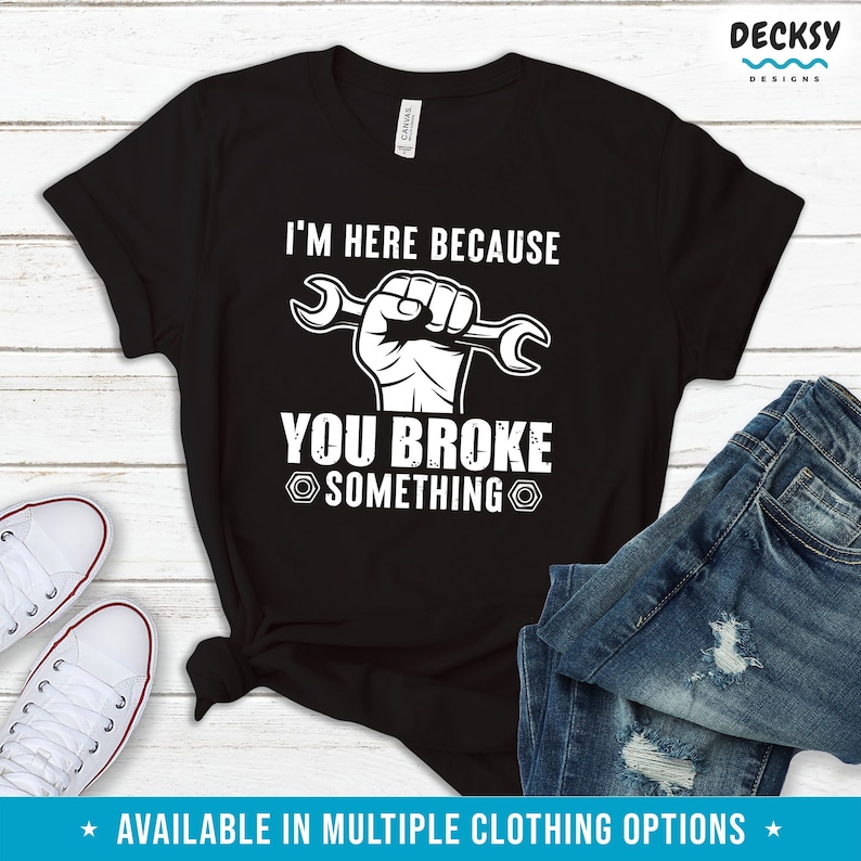 Puede incluir: Camiseta negra con texto blanco que dice "Estoy aqu&iacute; porque rompiste algo." Un pu&ntilde;o blanco sosteniendo una llave inglesa est&aacute; sobre el texto.