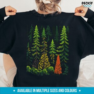 May include: Black sweatshirt with a colorful graphic design of a forest scene. The design features green, yellow, orange, and brown trees.