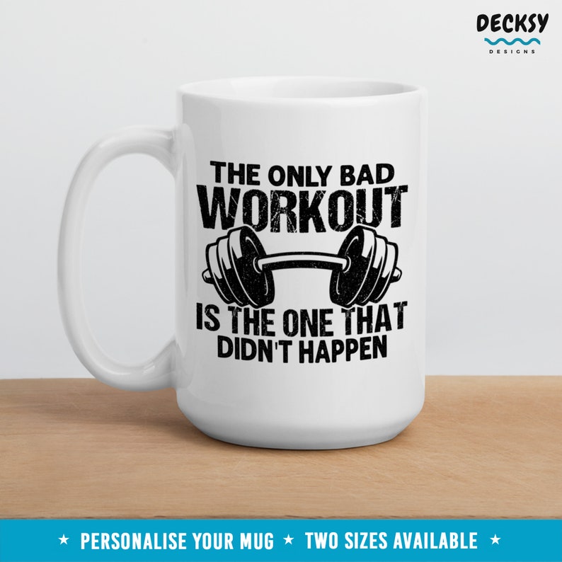 May include: White ceramic mug with a black graphic that reads "The only bad workout is the one that didn't happen." The graphic also features a black dumbbell.
