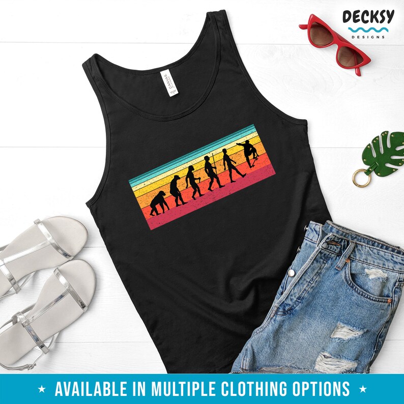 May include: Black tank top with a retro-style graphic of human evolution ending with a skateboarder. The graphic has a colorful striped background. The text "AVAILABLE IN MULTIPLE CLOTHING OPTIONS" is at the bottom.