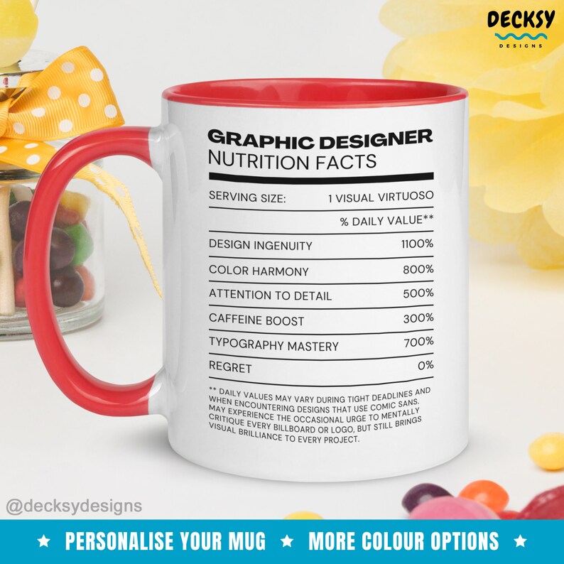 May include: White ceramic mug with a red rim and handle. The mug features a graphic design nutrition facts label with the text "Graphic Designer Nutrition Facts" and a list of design skills with their percentage daily value. The text at the bottom of the mug reads "Personalize Your Mug" and "More Color Options".