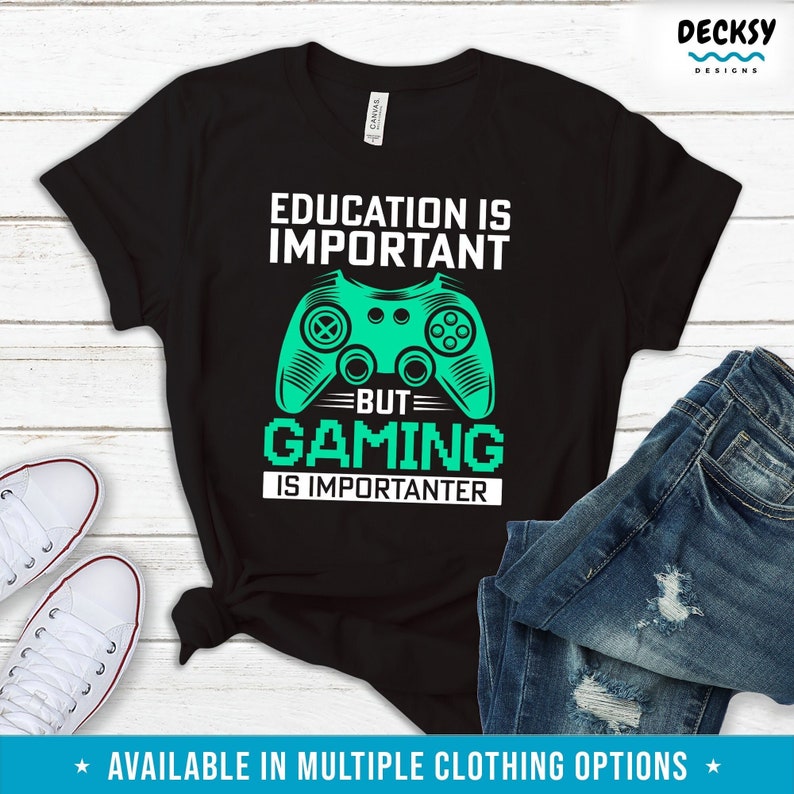 K&ouml;nnte beinhalten: Schwarzes T-Shirt mit einem gr&uuml;nen Videospiel-Controller-Motiv und dem Text "Bildung ist wichtig, aber Gaming ist wichtiger".
