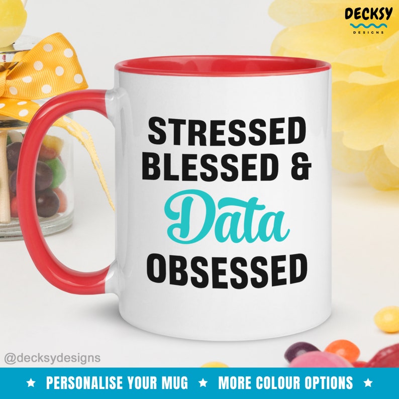 May include: White ceramic mug with a red rim. The mug has a black and teal design that says "Stressed Blessed & Data Obsessed".