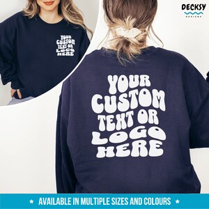 May include: A navy blue sweatshirt with white text that reads "YOUR CUSTOM TEXT OR LOGO HERE" in a retro, bubble-letter font.