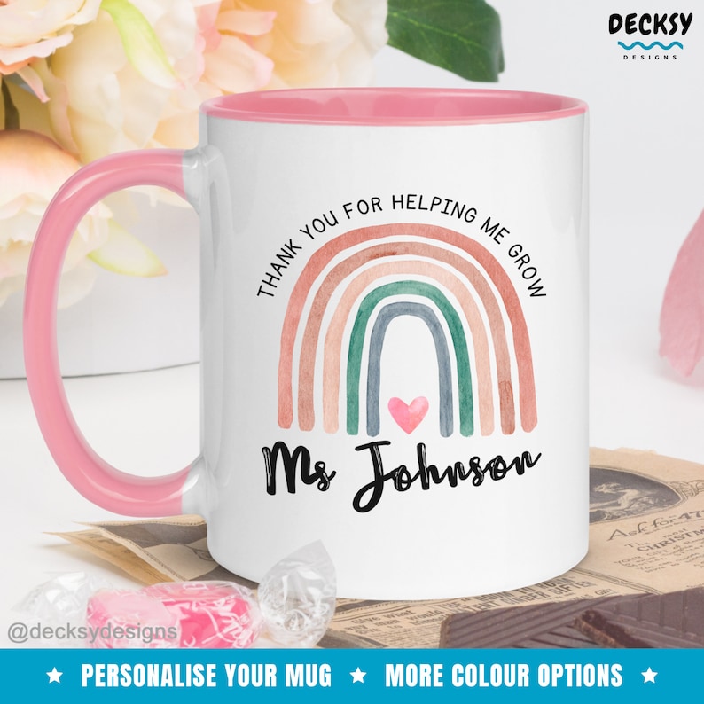 May include: White ceramic mug with a pink rim and handle. The mug features a watercolor rainbow with a pink heart in the center and the text "Thank you for helping me grow" and "Ms. Johnson".