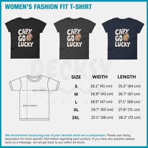 May include: A size chart for a women's t-shirt with the text "CAPY GO LUCKY" printed on it. The chart shows the width and length of the shirt in inches and centimeters for sizes S, M, L, XL, and 2XL.