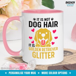May include: White ceramic mug with a pink rim and handle. The mug features a golden retriever dog illustration with the text "It is not dog hair, it is golden retriever glitter".