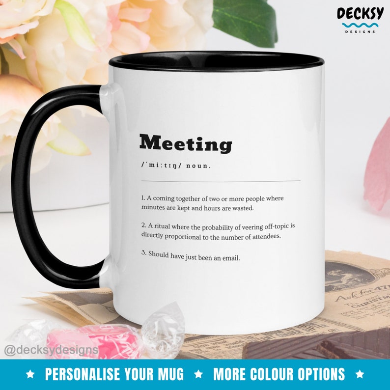 Pode incluir: Caneca de caf&eacute; branca com borda e al&ccedil;a pretas. A caneca apresenta um gr&aacute;fico em preto e branco com a palavra "Meeting" definida como um encontro de duas ou mais pessoas onde os minutos s&atilde;o anotados e as horas s&atilde;o desperdi&ccedil;adas. A caneca tamb&eacute;m inclui o texto "@decksydesigns" e "Personalize sua caneca" e "Mais op&ccedil;&otilde;es de cores".