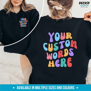 May include: Black sweatshirt with "YOUR CUSTOM WORDS HERE" in colorful, wavy letters. The text is on the back of the sweatshirt. The sweatshirt is available in multiple sizes and colors.
