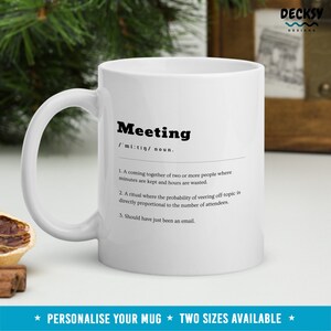 Pode incluir: Caneca de cer&acirc;mica branca com uma defini&ccedil;&atilde;o em preto e branco da palavra "Meeting" impressa nela. A defini&ccedil;&atilde;o &eacute;: "Um encontro de duas ou mais pessoas onde os minutos s&atilde;o mantidos e as horas s&atilde;o desperdi&ccedil;adas. Um ritual onde a probabilidade de desviar do t&oacute;pico &eacute; diretamente proporcional ao n&uacute;mero de participantes. Deveria ter sido apenas um e-mail."