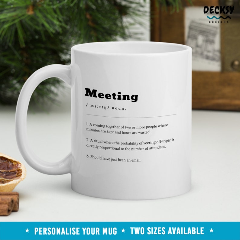 Pode incluir: Caneca de cer&acirc;mica branca com uma defini&ccedil;&atilde;o em preto e branco da palavra "Meeting" impressa nela. A defini&ccedil;&atilde;o &eacute;: "Um encontro de duas ou mais pessoas onde os minutos s&atilde;o mantidos e as horas s&atilde;o desperdi&ccedil;adas. Um ritual onde a probabilidade de desviar do t&oacute;pico &eacute; diretamente proporcional ao n&uacute;mero de participantes. Deveria ter sido apenas um e-mail."