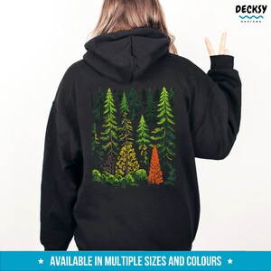 May include: Black hoodie with a graphic print of a forest scene with green, orange, and yellow trees. The text "AVAILABLE IN MULTIPLE SIZES AND COLOURS" is printed below the graphic.