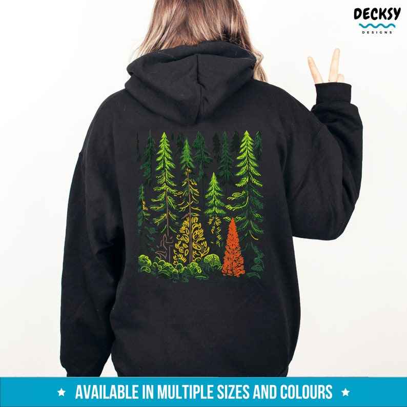 May include: Black hoodie with a graphic print of a forest scene with green, orange, and yellow trees. The text "AVAILABLE IN MULTIPLE SIZES AND COLOURS" is printed below the graphic.