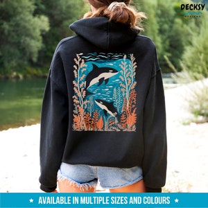 May include: Black hoodie with a graphic print of two orcas swimming in a blue ocean with coral and seaweed. The graphic is on the back of the hoodie.