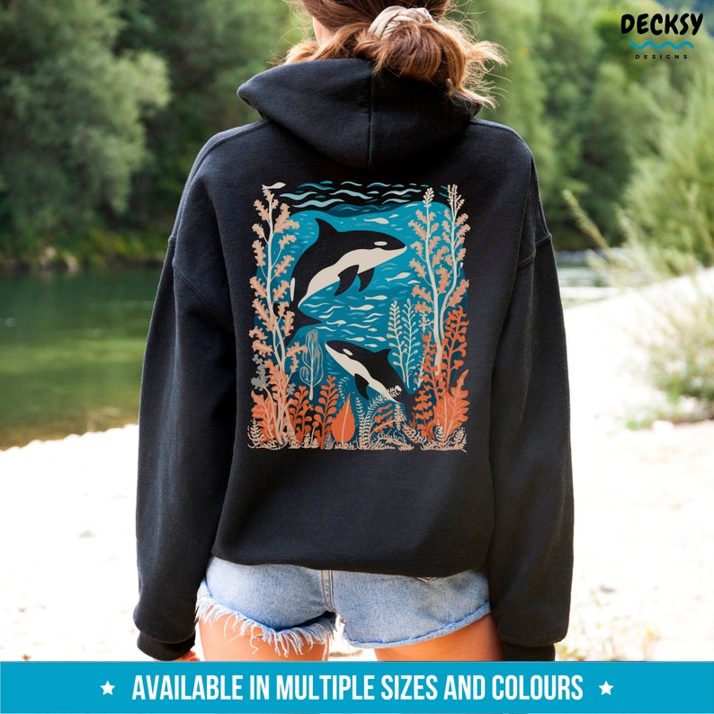 May include: Black hoodie with a graphic print of two orcas swimming in a blue ocean with coral and seaweed. The graphic is on the back of the hoodie.