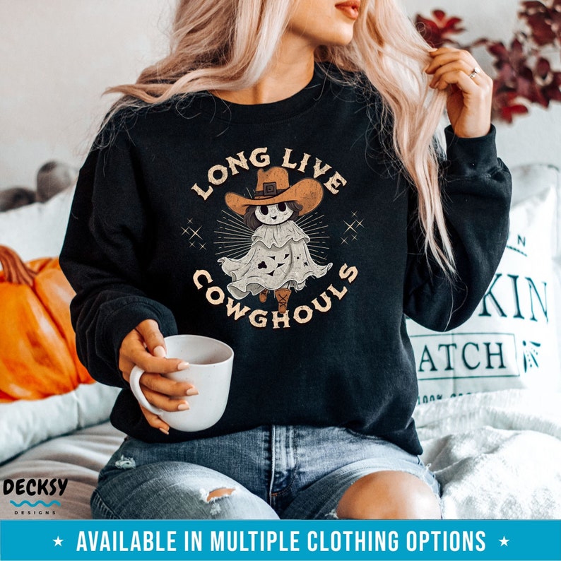 May include: Black sweatshirt with a graphic of a ghost wearing a cowboy hat and boots, with the text "LONG LIVE COWGHOULS". The design is in shades of brown, beige, and white. A Halloween-themed apparel item.