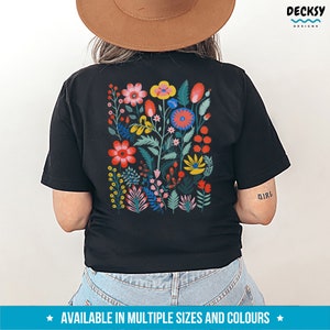 May include: Black t-shirt with a colorful floral design on the back. The design features a variety of flowers in shades of red, pink, yellow, blue, and green. The text "GIRL" is printed on the right sleeve.