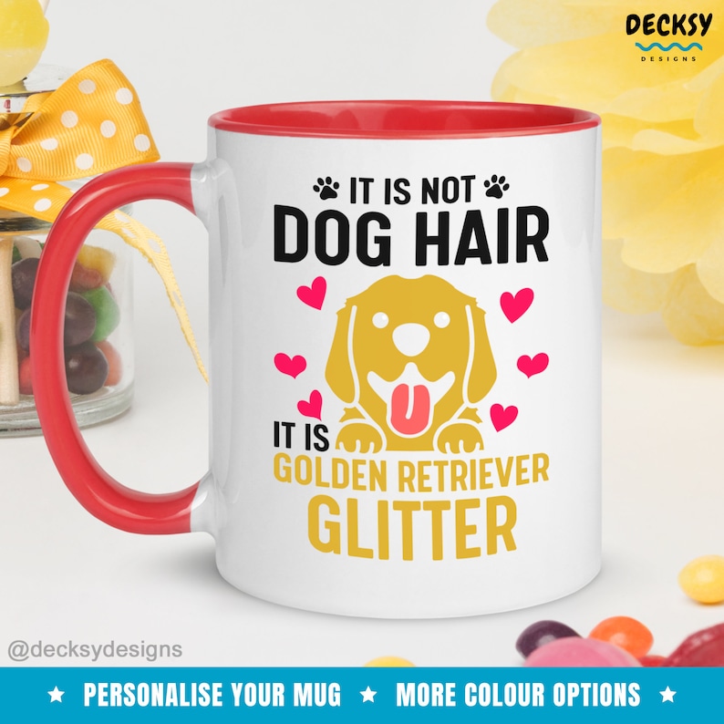 May include: White ceramic mug with a red rim. The mug features a golden retriever dog with a pink tongue sticking out. The text on the mug reads "It is not dog hair, it is golden retriever glitter".