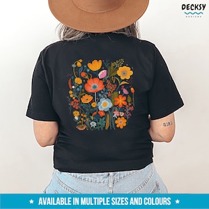 May include: Black t-shirt with a colorful floral print on the back. The print features a variety of flowers in shades of orange, yellow, pink, blue, and green. The shirt is available in multiple sizes and colors.