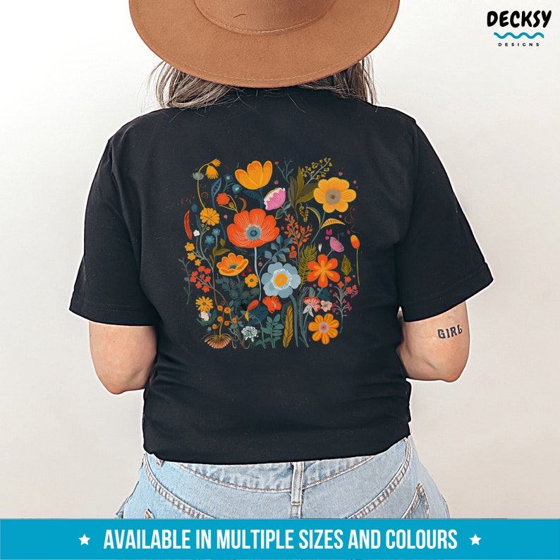 May include: Black t-shirt with a colorful floral print on the back. The print features a variety of flowers in shades of orange, yellow, pink, blue, and green. The shirt is available in multiple sizes and colors.