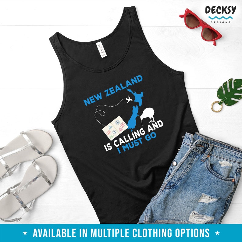 May include: Black tank top with a blue graphic of New Zealand, a kiwi bird, and an airplane. The text "New Zealand is calling and I must go" is printed on the shirt.