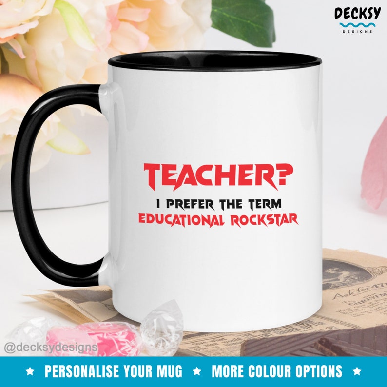 K&ouml;nnte beinhalten: Wei&szlig;e Keramiktasse mit schwarzem Rand und Henkel. Die Tasse tr&auml;gt den roten Text "TEACHER? I PREFER THE TERM EDUCATIONAL ROCKSTAR".