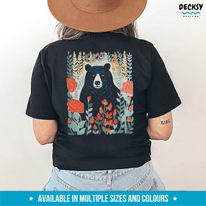 May include: Black t-shirt with a graphic print of a black bear in a forest with red and green flowers. The text "Girl" is printed on the right sleeve.