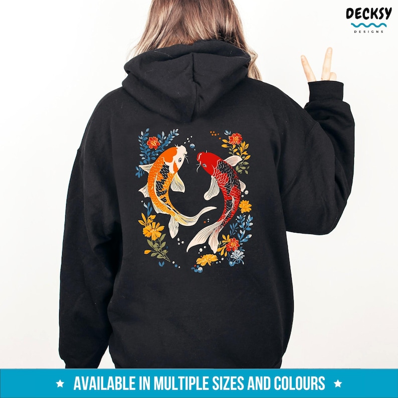 May include: Black hoodie featuring a design of two koi fish swimming in opposite directions, surrounded by colourful flowers. The design is on the back of the hoodie.