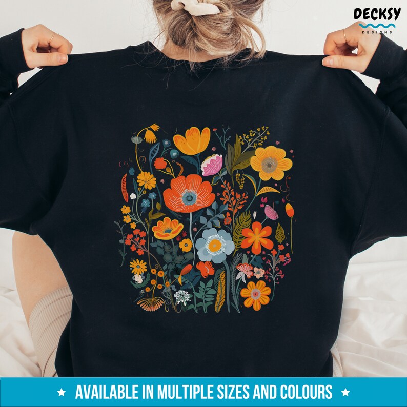 May include: Black sweatshirt with a colorful floral print featuring various flowers, leaves, and stems in shades of orange, yellow, red, blue, green, and pink.
