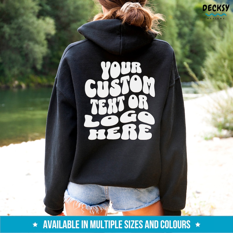 May include: Black hooded sweatshirt with white text that reads "YOUR CUSTOM TEXT OR LOGO HERE" in a retro font.