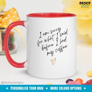 May include: White ceramic coffee mug with a red rim. The mug has black text that reads "I am sorry for what I said before I had my coffee" with a gold heart below the text.