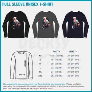 May include: A black, grey, and navy blue long-sleeved t-shirt with a pink cockatoo riding a bicycle graphic. The t-shirt is available in sizes XS-2XL. The size chart shows the width and length of the shirt in inches and centimeters.
