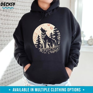 May include: Black hoodie with a graphic print of a wolf howling at the moon in a forest setting. The moon is yellow with red stars and the wolf is black. The forest is green and brown.