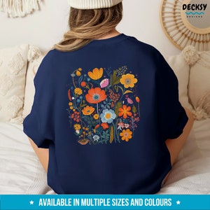 May include: A navy blue sweatshirt with a colorful floral print on the back. The print features a variety of flowers in shades of orange, yellow, red, pink, and blue.