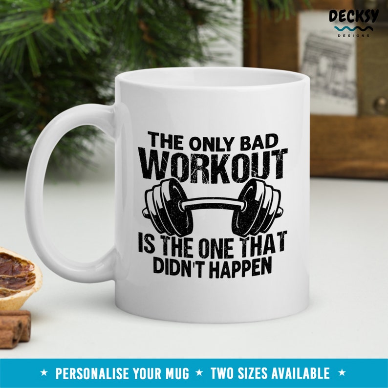 May include: White ceramic mug with a black and white graphic of a barbell and the text "The only bad workout is the one that didn't happen".