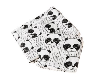 May include: A white muslin swaddle blanket with a black and white panda print. The pandas have a cute, cartoon-like expression.
