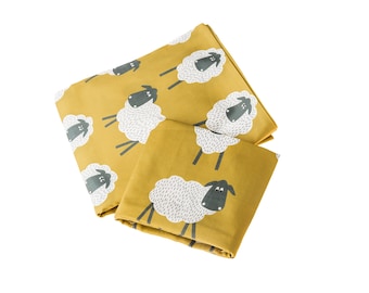 May include: A set of two yellow bedding pieces featuring a white sheep pattern. The sheep have black faces and white spots.