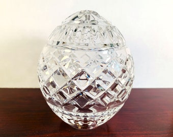 May include: A clear crystal egg with a diamond pattern. The egg is about 4 inches tall and 3 inches wide.
