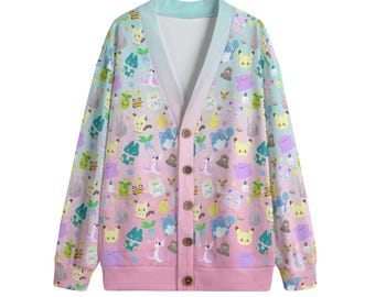 Könnte beinhalten: Eine pastellfarbene Strickjacke mit V-Ausschnitt und Knopfverschluss. Der Stoff ist mit einem sich wiederholenden Muster aus gelben, blauen, rosa und grünen Cartoon-Figuren bedeckt. Der Saum und die Manschetten sind rosa.