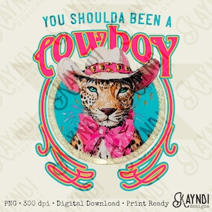 May include: A digital graphic featuring a leopard wearing a cowboy hat and a pink scarf. The text "YOU SHOULDA BEEN A COWBOY" is displayed above the leopard in a vibrant pink and turquoise color scheme. The design has a vintage, country aesthetic.