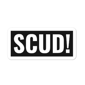 May include: Black and white sticker with the word "SCUD!" in white letters.