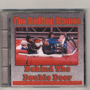 Puede incluir: Un coche rojo convertible con cuatro personas dentro. El coche está etiquetado con "The Rolling Stones Behind The Double Door The Legendary Secret Gig Chicago, Illinois Sept 18, 1997".