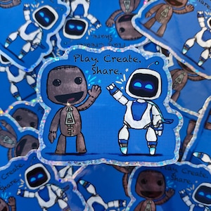 May include: A sticker featuring two cartoon characters on a blue background. One character is brown with a zipper design, and the other is white and blue. The text "Play. Create. Share." is above the characters.
