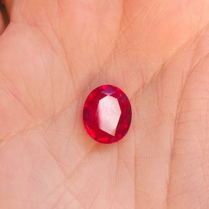 Peut inclure: Une pierre précieuse ovale de couleur rouge foncé avec une taille facetée.