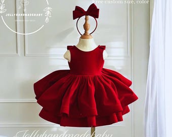 May include: A deep red velvet dress with a sleeveless bodice, a full pleated skirt with multiple layers, and a matching red velvet bow headband. The text "Design by Jollyhandmadebaby" and "Free custom size, color" is visible in the upper right corner.