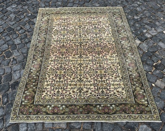 May include: A vintage cream-colored rug with a floral pattern in shades of green, red, and black. The rug has a border with a repeating pattern of birds and flowers.