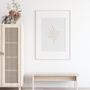 May include: A white wooden cabinet with glass doors and a woven rattan insert. A framed print of a line drawing of a bouquet of flowers hangs above a white wooden bench.