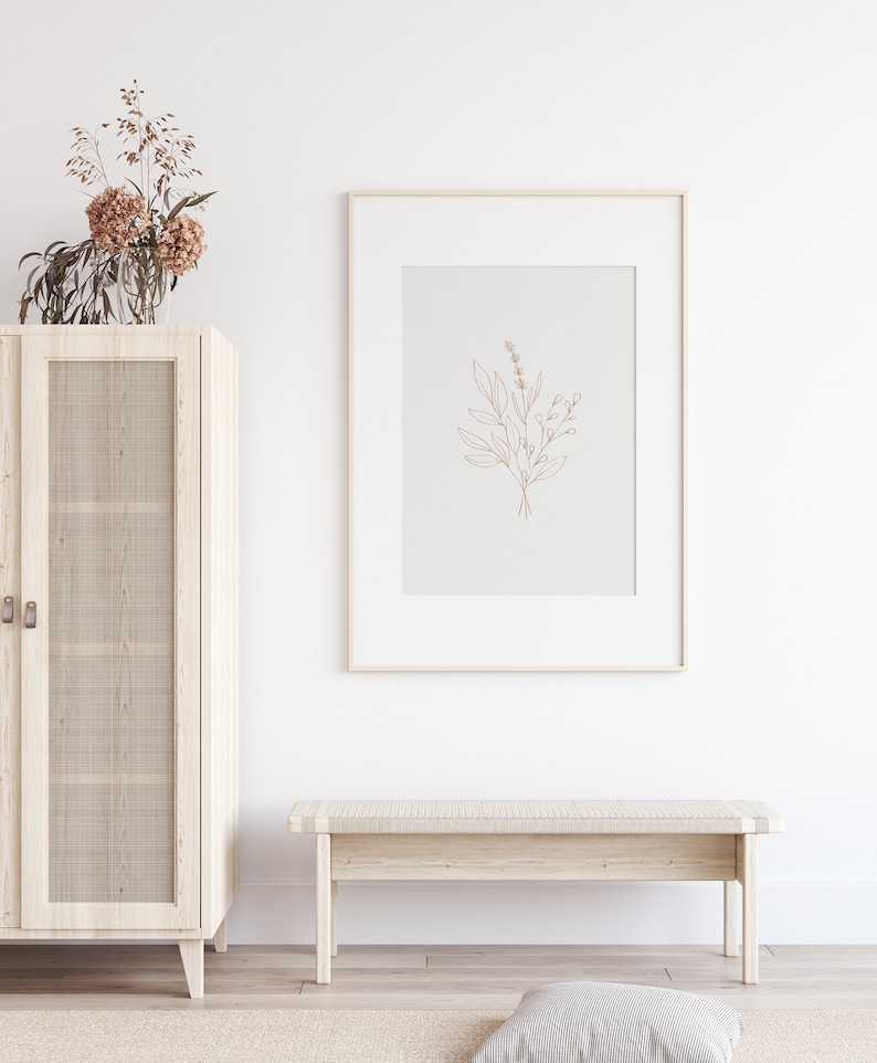 May include: A white wooden cabinet with glass doors and a woven rattan insert. A framed print of a line drawing of a bouquet of flowers hangs above a white wooden bench.