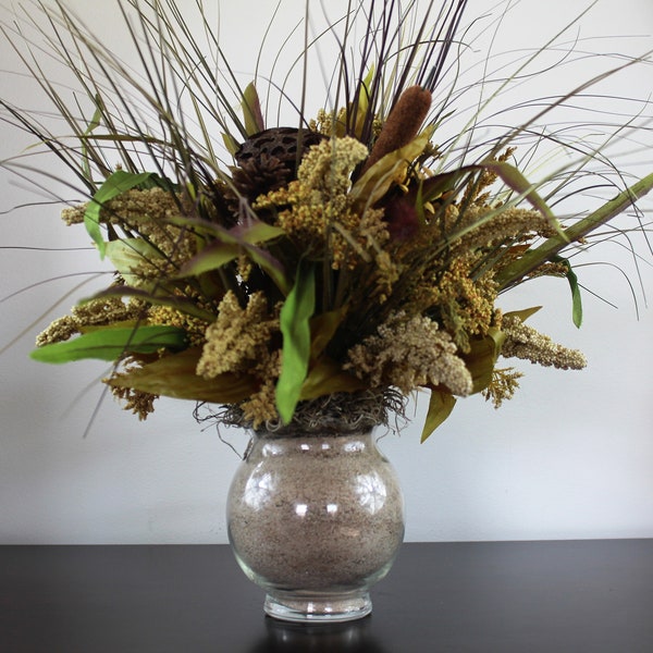 Natural Accent Centerpiece Designed with Pods, Cattails, Natural Accents, Grasses in a Sand Filled Glass Vase