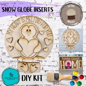 May include: DIY snow globe kit with a penguin holding a heart and the text "My heart is melting for you". The kit also includes a wooden sign with the text "home sweet home" and a cupcake graphic. The kit comes with paint and a paintbrush.